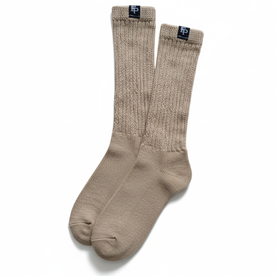 Pair of beige socks with a brand label on a white background