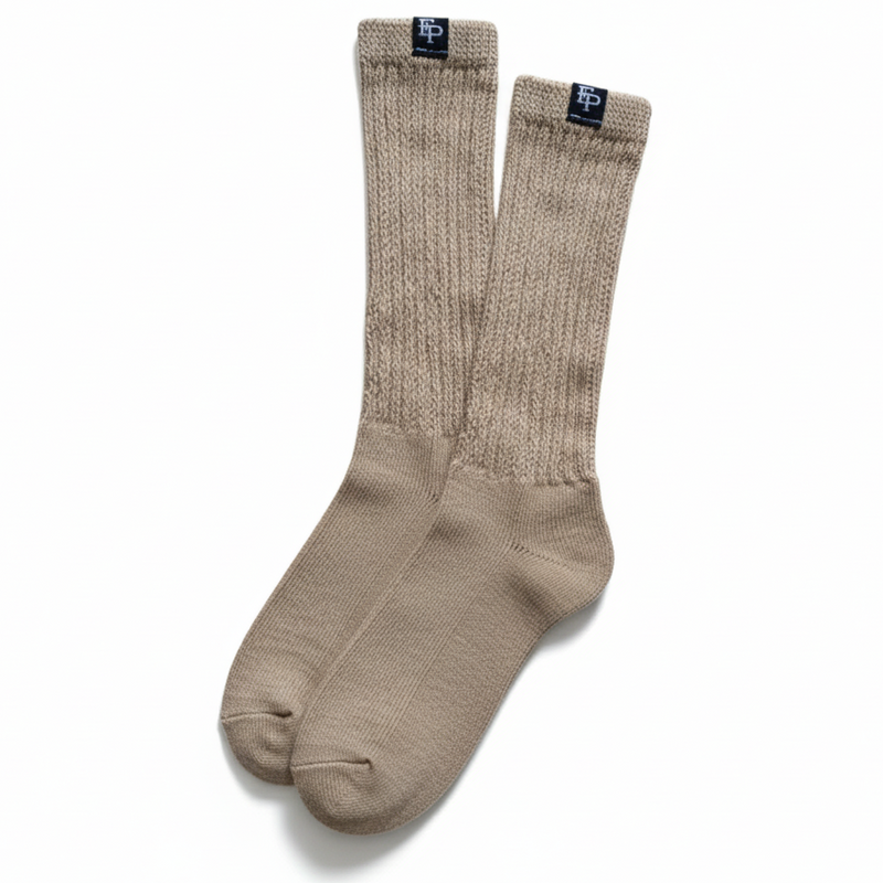 Pair of beige socks with a brand label on a white background