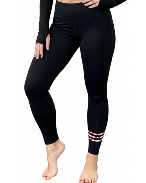 Black leggings with striped cuffs worn by a person on a white background