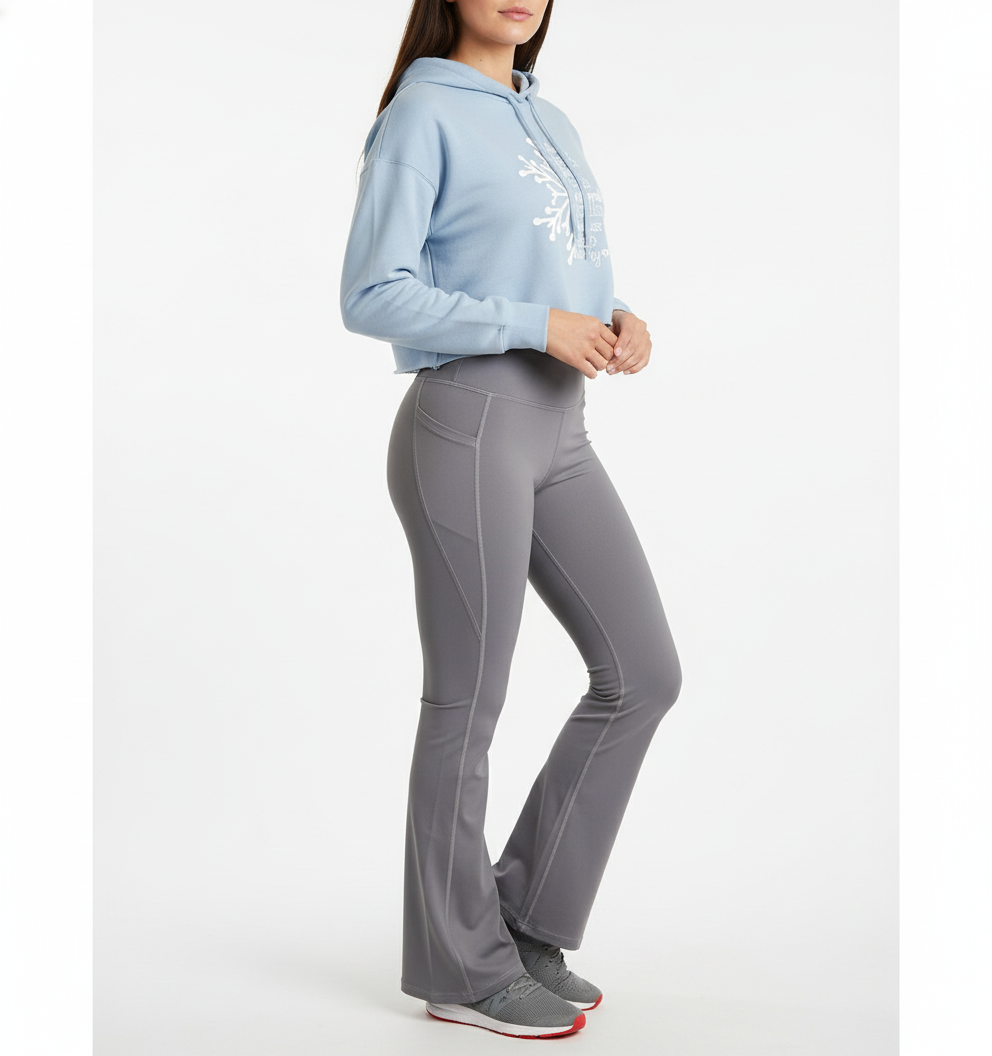 Person wearing a light blue hoodie and gray flared pants on a white background