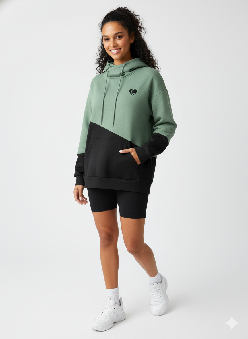 Woman wearing a green and black two-tone hoodie with black shorts on a white background